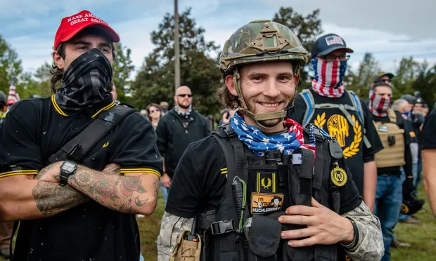 A group of Proud Boys wearing tactical gear and their signature black and yellow Fred Perry polo shirts (Photo from The Guardian).